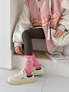 Detail showing pink cotton crew socks with embroidered white heart and Love text
