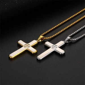 Detailed view of gold and silver cross pendants with brushed metal and zircon inlay