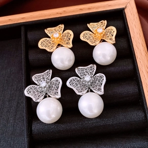 Close-up of 18K gold plated flower pearl earrings with textured hollow petals