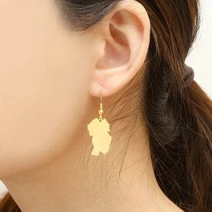 Detailed view of a gold poodle silhouette earring worn by a model to show texture and scale