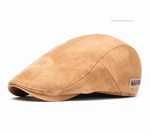 Close-up of khaki tie-dye ivy cap showing suede texture and circular GSIOR metal badge
