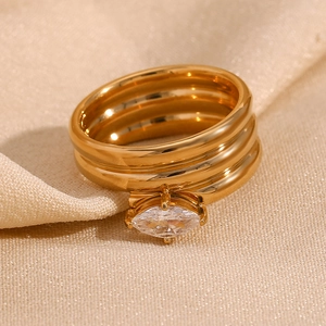 Gros plan sur la bague multicouche plaquée or 18K avec zircon marquise sur soie champagne
