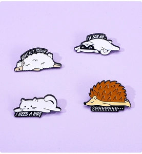 Detail of four enamel animal pins including a sheep and cat with funny English phrases