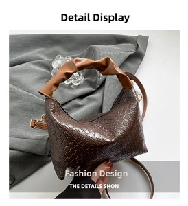 Close-up of brown woven texture handbag with scrunchie handle and gold hardware detail