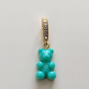 Close-up of a turquoise resin gummy bear pendant with a gold crystal-encrusted clasp