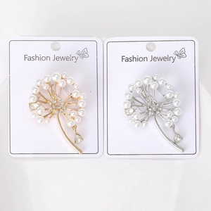 Détail de broches pissenlit en argent et or avec perles sur cartes de bijoux