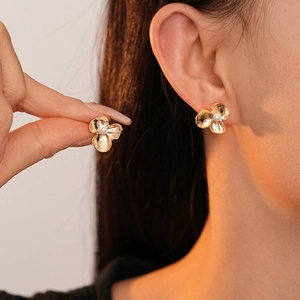 Minimalist golden three-petal flower stud earrings with pearl and hammered metal finish