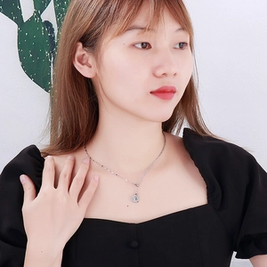 Elegant silver stainless steel necklace with round pendant worn by a model on black outfit