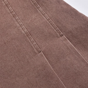 Détail de double couture et texture de denim marron épais sur une robe sans manches