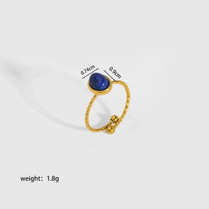Detail view of gold geometric open ring featuring a blue oval natural stone inlay