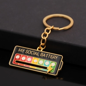Macro detail of rainbow social battery keychain with enamel finish and mood emoji icons