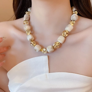 Detailed close-up of irregular acrylic marble beads and gold alloy links on a chunky necklace