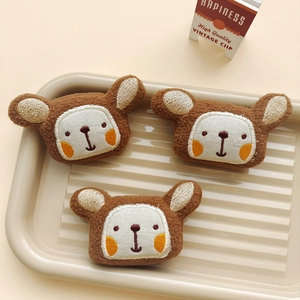 Set of three cute brown plush bear head accessories with embroidery on a wave tray