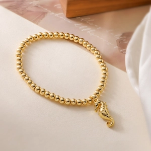 18K gold-plated beaded bracelet with sparkling seahorse charm on white silk