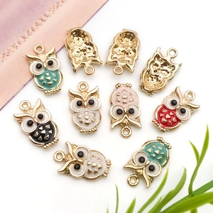 Detail of colorful owl charms in gold finish with vibrant enamel inlay for jewelry making