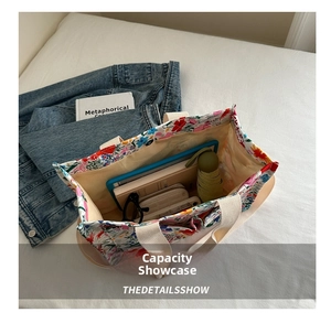 Top-down view of spacious floral canvas tote bag holding a tablet, umbrella, and wallet
