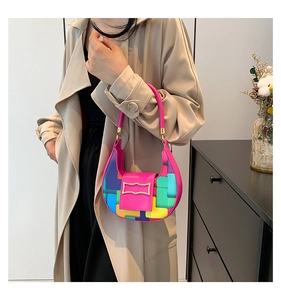 Close-up of a crescent moon bag in rose red PU leather with colorful block patchwork