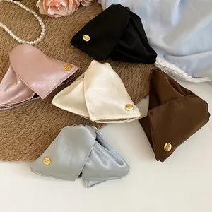 Elegant satin triangle hair claws in five colors with vintage gold buttons on woven mat