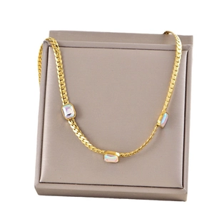 Gold snake chain necklace with three rectangular opals displayed in a grey jewelry box