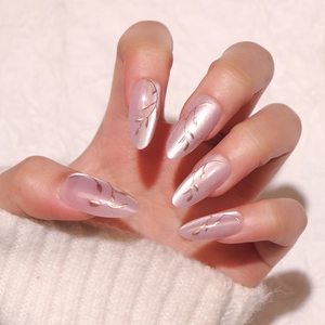 Elegant cat-eye almond press-on nails with golden leaf patterns in translucent pink finish