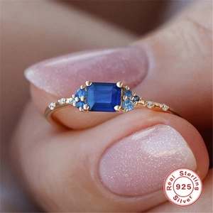 Detail of 925 sterling silver gold plated ring with blue rectangle zircon and pavé stones