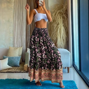 Women's summer bohemian outfit with white crop top and black floral high waist maxi skirt