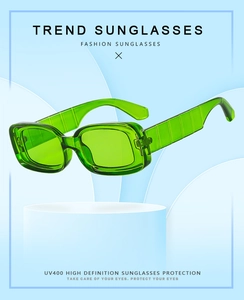 Green square frame sunglasses with UV400 protection on a minimalist display stand