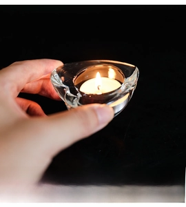 Close-up of heart-shaped glass candle holder with a tea light held in hand
