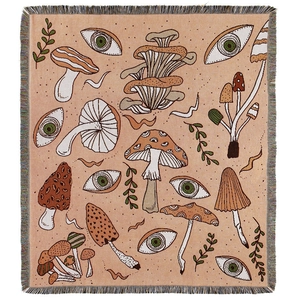 Bohemian woven blanket with mushroom and eye patterns featuring peach pink tassels
