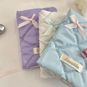 Detailed view of quilted satin passport holders with elegant bows in purple and blue