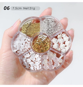 Macro view of nail art mixed charms in floral acrylic box with metal beads and 3D flowers