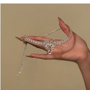Detail of silver bow choker with sparkling rhinestones and drop pearl pendant