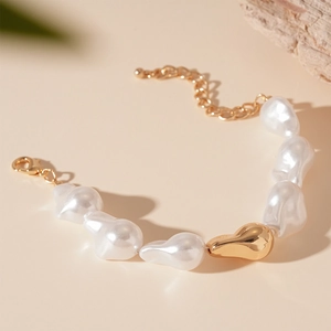 Détail d'un bracelet en perles baroques avec perle en métal doré et fermoir mousqueton