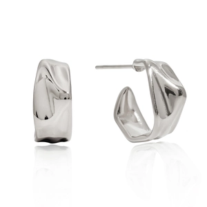 Macro detail of silver C-shaped titanium steel earrings with irregular lava texture