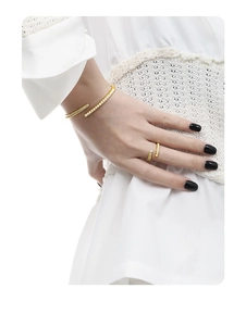 Close-up of a model wearing a gold S925 sterling silver bangle and matching ring set