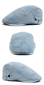 Detail view of washed denim flat cap showing adjustable brass buckle and retro texture
