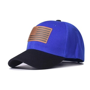 Close-up of color-block baseball cap featuring a leather American flag patch and twill texture