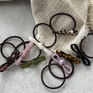 Set of 7 colorful acetate bow hair ties in pink, green, and tortoiseshell styles