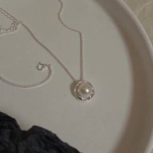 Close-up of S925 sterling silver necklace with freshwater pearl in wavy base