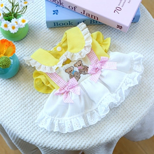 Close-up of dog princess dress with bear embroidery, pink bow, and white lace texture