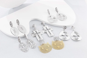 Vue détaillée des boucles d'oreilles géométriques argentées avec croix et gouttes