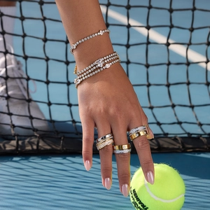 Klassisches 18K Edelstahl-Tennisarmband-Set mit Zirkonia auf einem Tennisplatz
