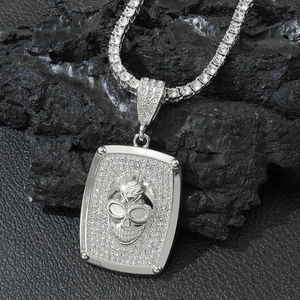 Pendentif tête de mort en argent avec chaîne tennis sertie sur fond de pierre noire