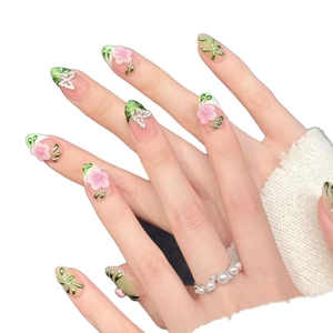 Unghie finte sfumate rosa e verdi con fiori 3D e decorazioni a farfalla glitterata