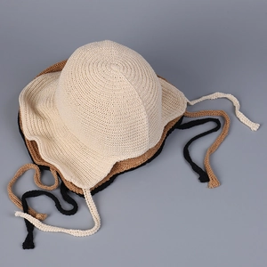 Close-up of knit texture on sun hats in beige, khaki, and black with ribbon straps