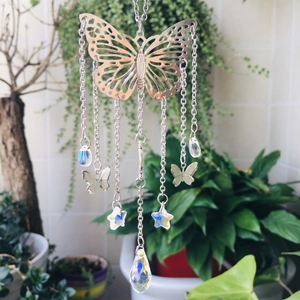 Close-up of a silver butterfly suncatcher with star crystals and a prism teardrop
