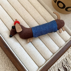 Detailed close-up of a corduroy dachshund hair clip with polka dot and denim accents