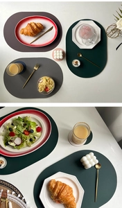 Detailed view of oval PU leather placemats and coasters in mixed modern grey and green colors