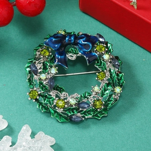 Detail of Christmas wreath brooch with colorful rhinestones and blue bow on holiday background