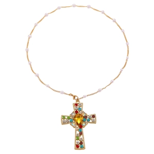 Detailed view of a gold chain necklace with small pearls and a rhinestone cross pendant